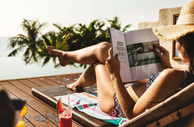 Woman reading print magazine at a resort